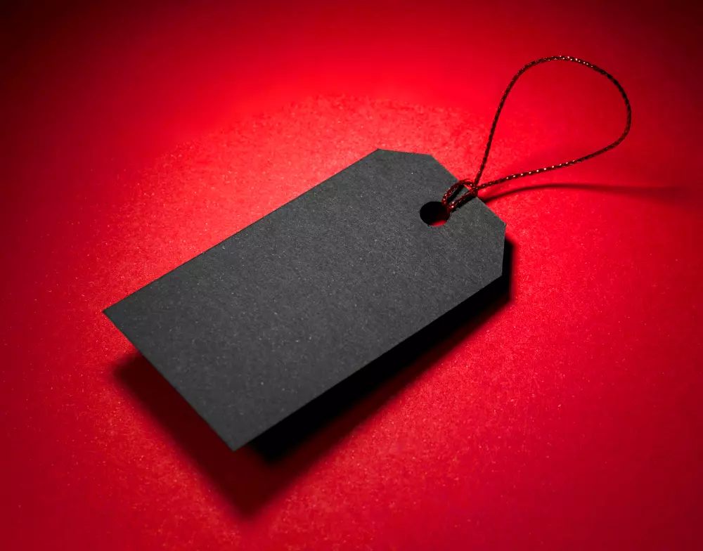 Etiqueta negra para productos con cordón rojo, un ejemplo de impresión de etiquetas para productos que combina diseño minimalista y elegancia para destacar en el mercado.